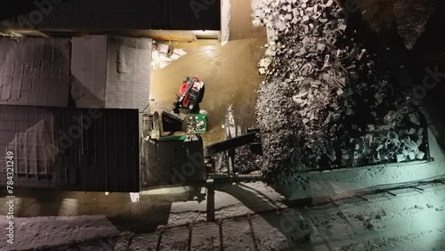 Drone footage of metal recycling facility and machine sorting out metal at night during winter night photo