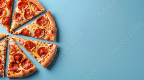 Pepperoni pizza slices and cherry tomatoes on blue background with copy space