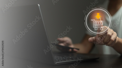 A person is using a laptop with a shopping cart icon on the screen