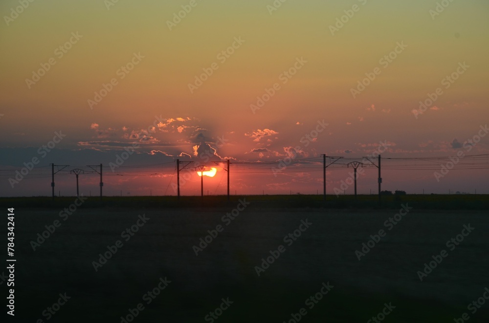 Beautiful scene of the silhouette of the powerlines with an orange sky at sunset