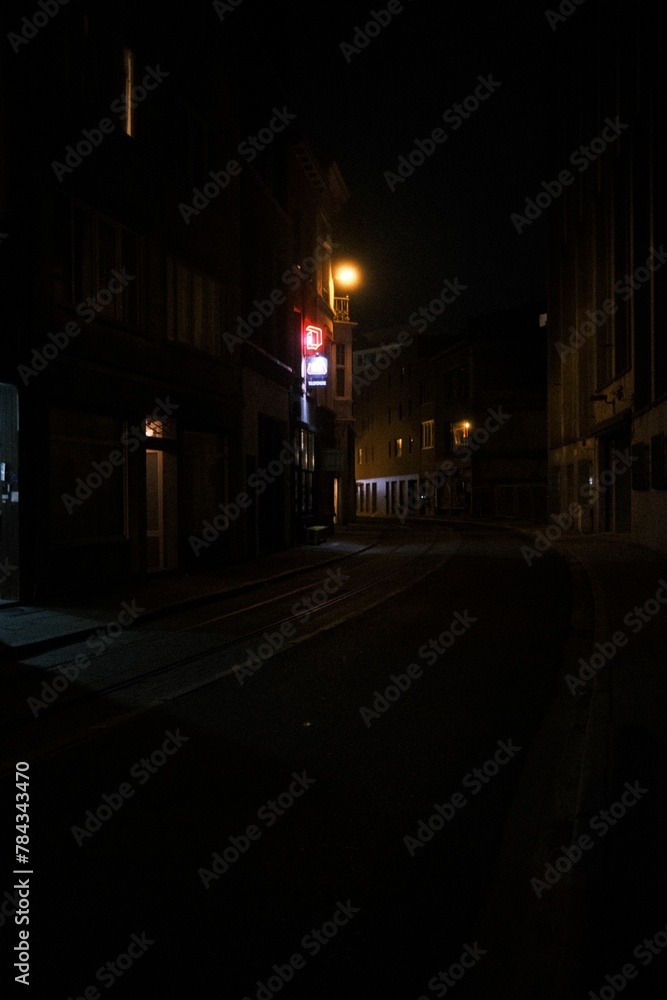 Narrow street surrounded by buildings in night