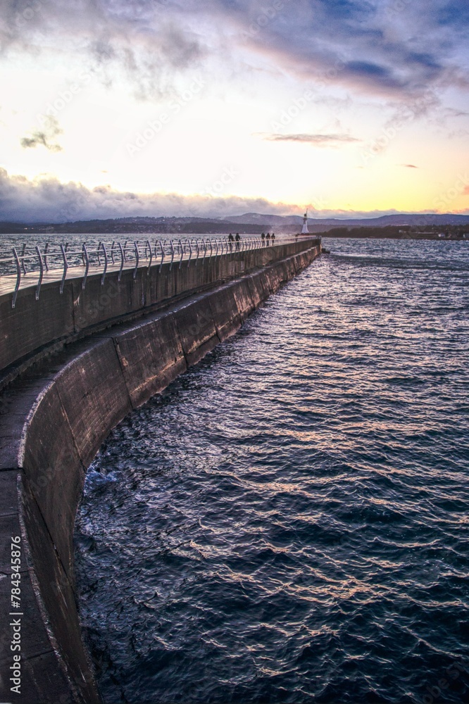 Vertical shot of a big breakwater in Victoria, British Columbia with a lighthouse on the horizon Vertical shot of a big breakwater in Victoria, British Columbia with a lighthouse on the horizon