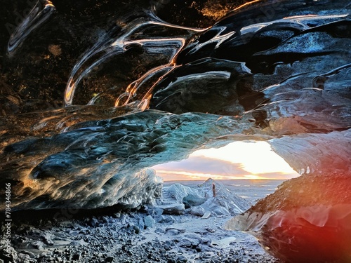 Ice cave of the Katla volcano with the sunset in the background in Iceland photo