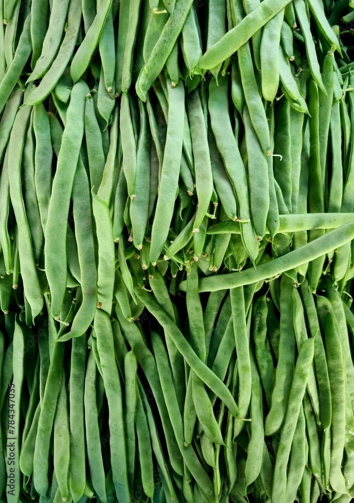 Vertical shot of green beans stacked in an outdoor maket on a sunny day Vertical shot of green beans stacked in an outdoor maket on a sunny day