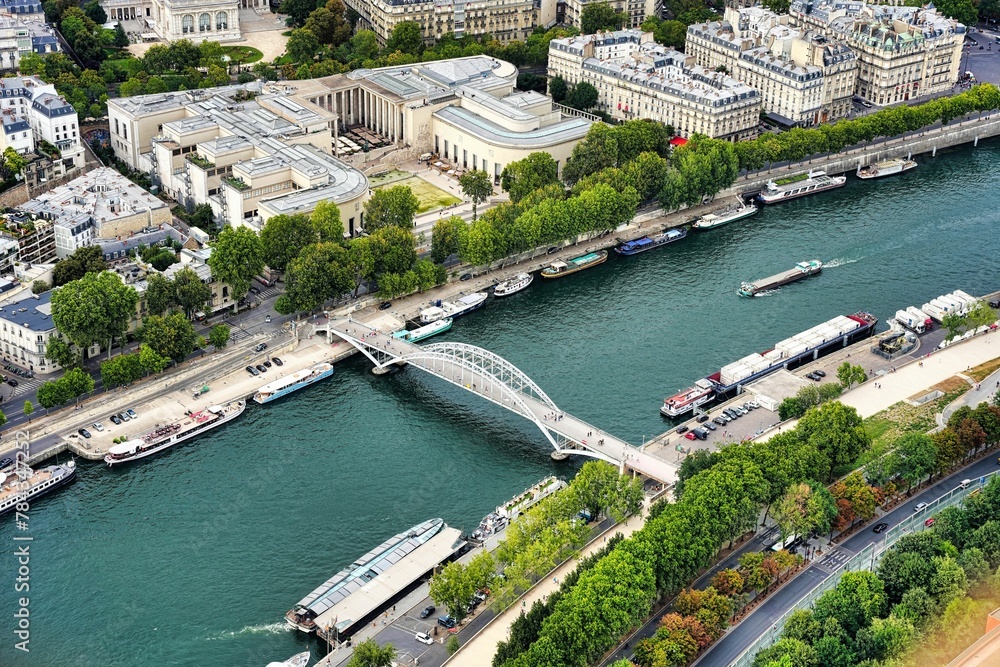 Aerial shot of a bridge over the Seine river with Paris city in the background during the daytime