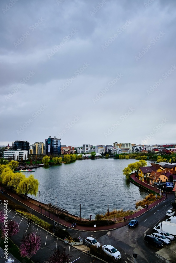 Cloudy sky in autumn, over a city park lake in Cluj-Napoca, Romania with a skyline in the background