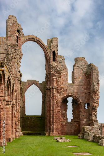The ruins of Lindisfarne Priory from the graveyard of the church of St. Mary the Virgin, Holy Island, Northumberland, UK