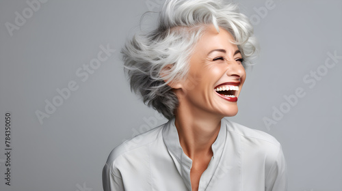 a woman with grey hair laughing with a big smile on her face photo