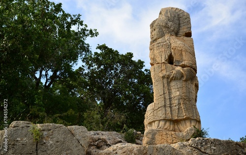 Closeup of a stone statue against a blue sky in the historic Arsameia, Turkey