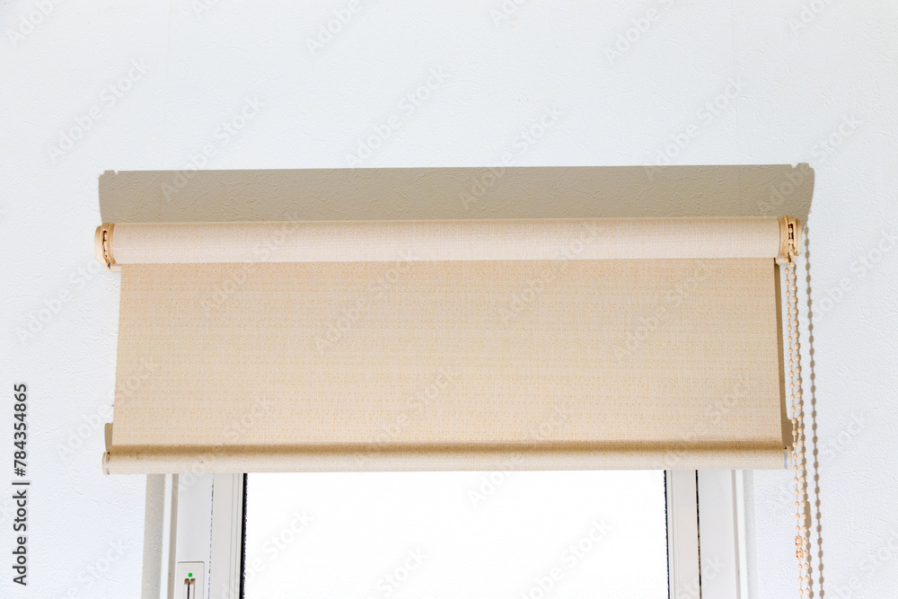 窓の上部に取り付けられたロールスクリーン