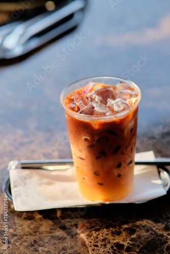 Vertical shot of a glass of iced coffee on the table in the cafe