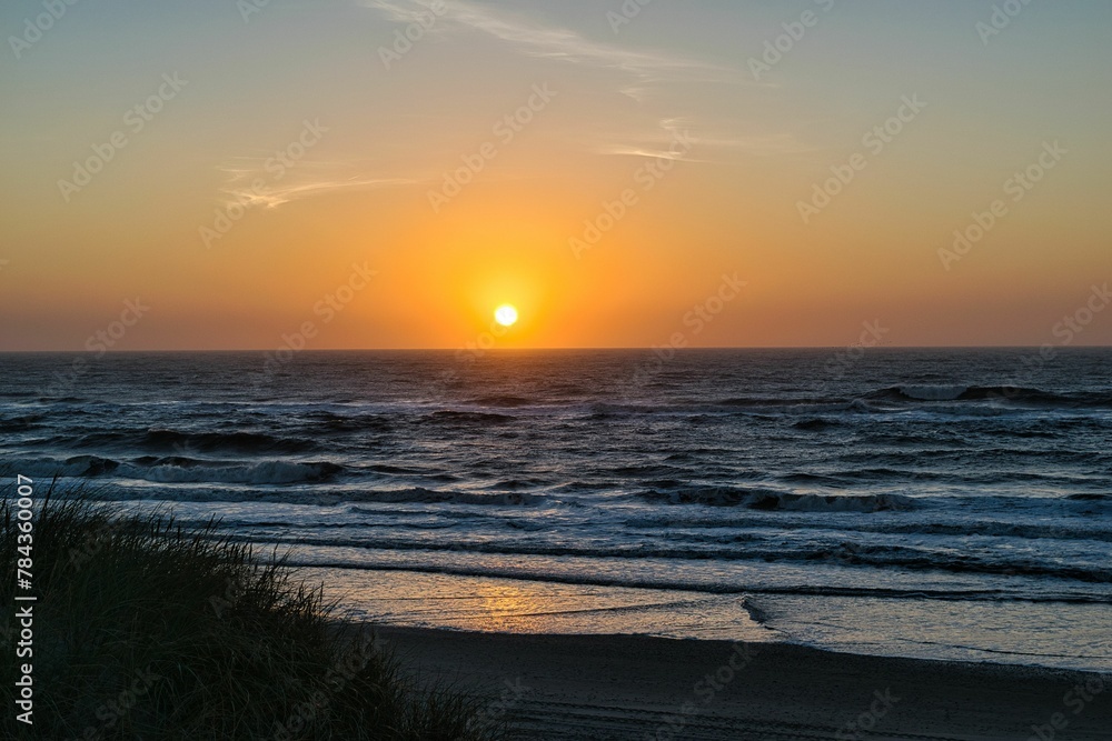 Beautiful sunset scene with the sea waves reflecting the sunlight in Ringkobing, Denmark