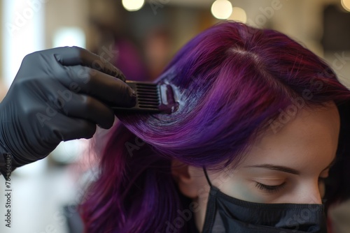 This image showcases the application of a rich purple hair dye by a stylist, perfect for content related to beauty salon services and color transformation.