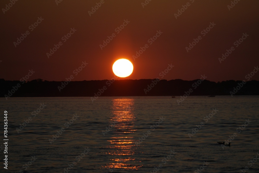 Scenic view of sunset over a calm coast and island