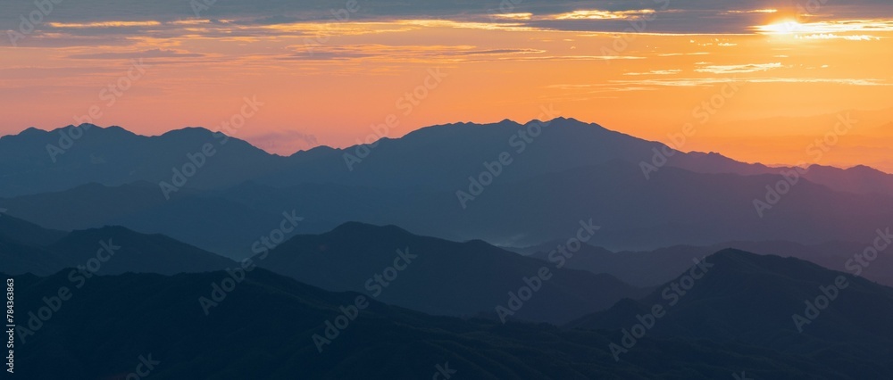 Beautiful view of a sunset over the silhouettes of the mountain range
