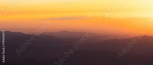 Beautiful view of a sunrise over the silhouettes of the mountain range © Wirestock