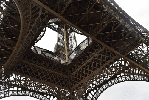 Low angle shot of the famous Eiffel tower in Paris against the cloudy sky during the daytime