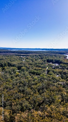 Vertical aerial view of Lake Cathie with a blue sky in the background, Australia