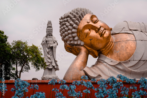 Buddha with hand on head with flowers