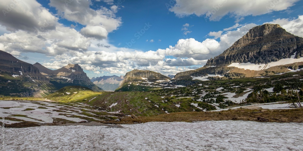 Rocky landscape with snow, mountain and blue cloudy sky in the Glacier National Park in Montana