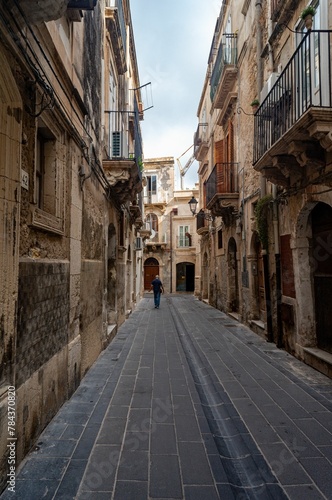 Fototapeta Naklejka Na Ścianę i Meble -  Vertical shot of a historic alley with old buildings in Syracuse, Sicily, Italy