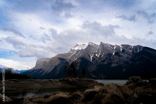 Glacial lake Minnewanka in the Banff national park with snowy mountains against the cloudy sky