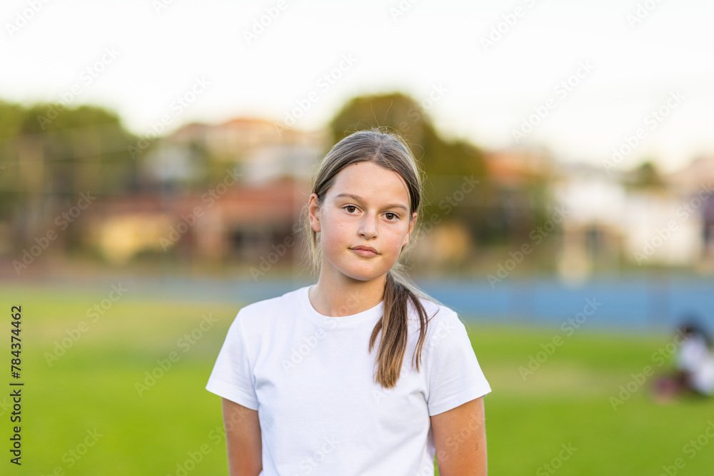 head and shoulders of twelve year-old girl outside wearing white tee-shirt head and shoulders of twelve year-old girl outside wearing white tee-shirt
