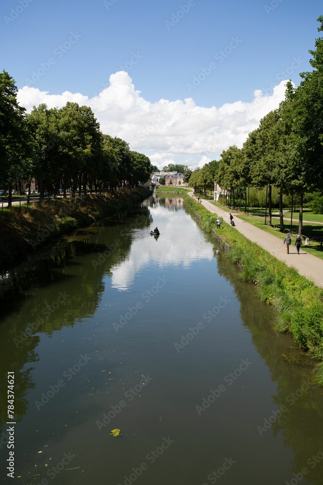 Vertical shot of a river flowing through a park in Amiens, France