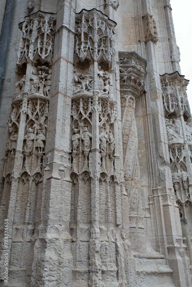 Vertical shot of beautiful columns with carvings in Rouen, France