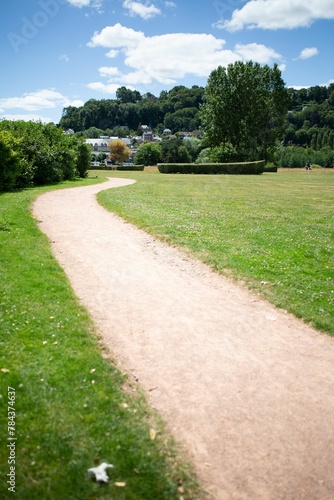 Fototapeta Naklejka Na Ścianę i Meble -  Vertical shot of a pathway surrounded by the lawn in Honfleur, France