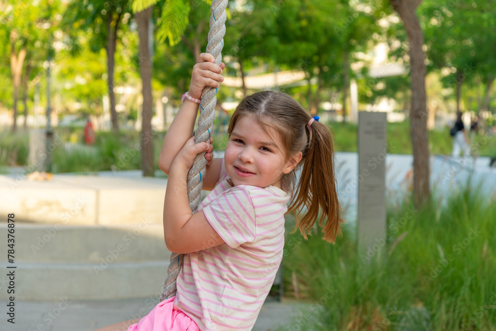 cute girl swinging on a rope at the playground cute girl swinging on a rope at the playground