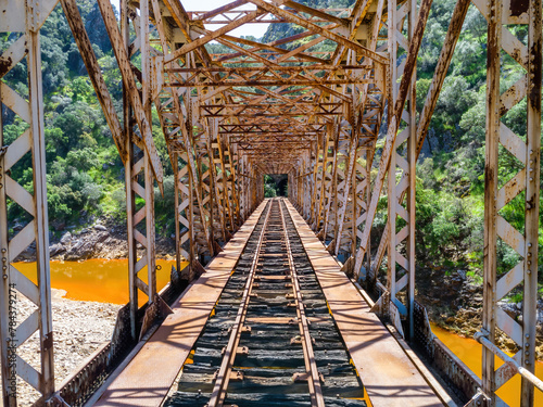 The Salomon Bridge crossing the red river, Rio Tinto, is a railway bridge in the province of Huelva and was originally part of the Riotinto railway for the transportation of copper mineral to Huelva photo