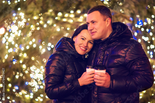 Couple drinking hot beverages at winter holidays