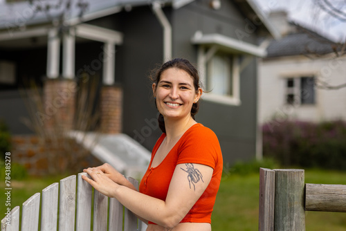 young woman at front gate outside older style home