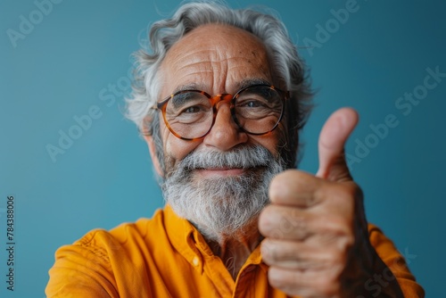 An elderly man with glasses giving a thumbs up, with a bright smile and a vibrant background