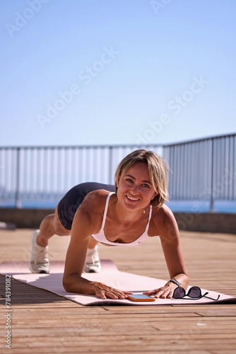 young caucasian woman in plank position, exercising outdoors. stretch whole body, lead healthy lifestyle.  © natapetrovich