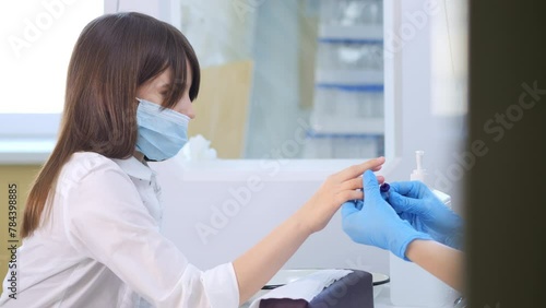 Doctor takes a patient's blood sample from a finger prick. Child's blood test. Blood test, blood group determination and medicine concept photo