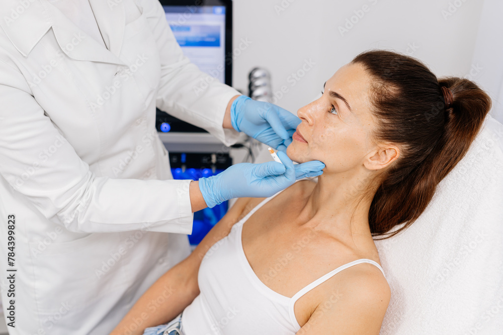 Close-up. Before the procedure for facial contouring or plastic surgery, the cosmetologist makes markings on the patient’s face. Time to prepare for a cosmetic procedure. Close-up. Before the procedure for facial contouring or plastic surgery, the cosmetologist makes markings on the patient’s face. Time to prepare for a cosmetic procedure.