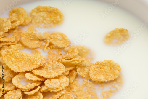 cereal with milk. yellow small cereals lie in milk, close-up, breakfast concept