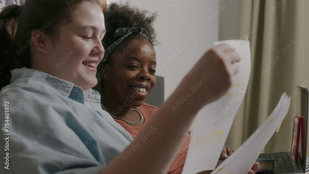 Waist up of two multiethnic student girls doing college homework ...