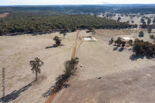 aerial view of bush and farmland with a track and whips of smoke photo