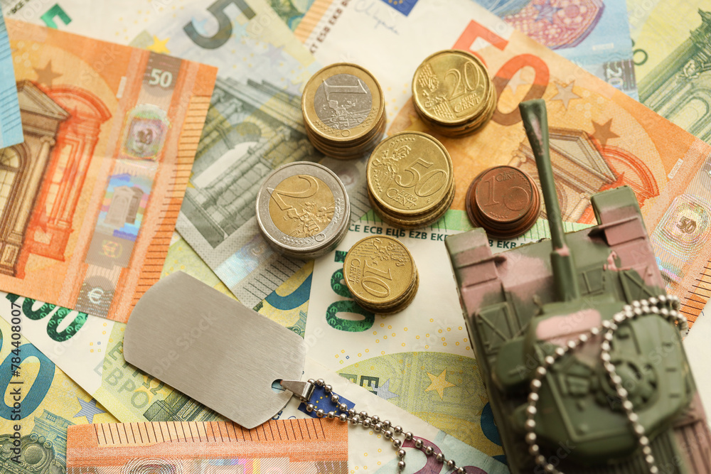 Many euro banknotes and tank. Lot of bills of European union currency and green tank close up Many euro banknotes and tank. Lot of bills of European union currency and green tank close up