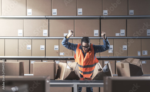 Angry rebellious worker smashing boxes at work