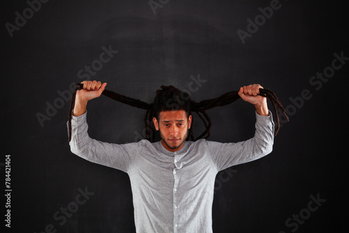 Rastafari young man next to a chalkboard