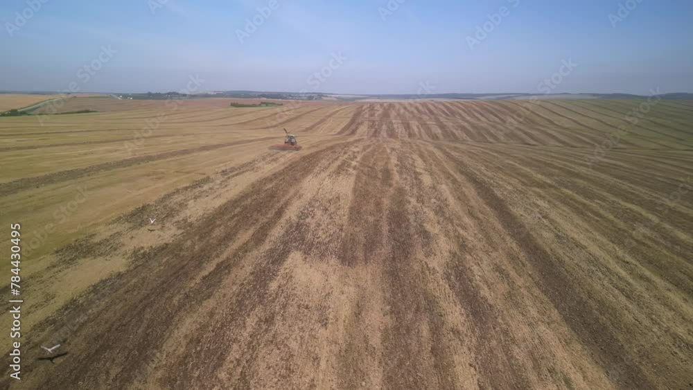 Tractor working on the field cultivating soil in Ukraine Tractor working on the field cultivating soil in Ukraine