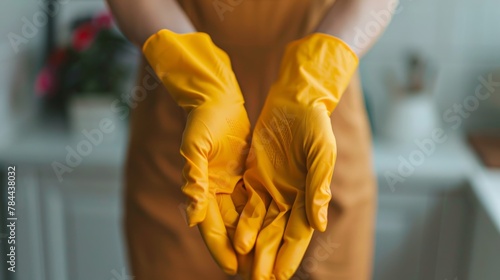 Close-up of female hands in yellow rubber gloves. Cleaning concept
