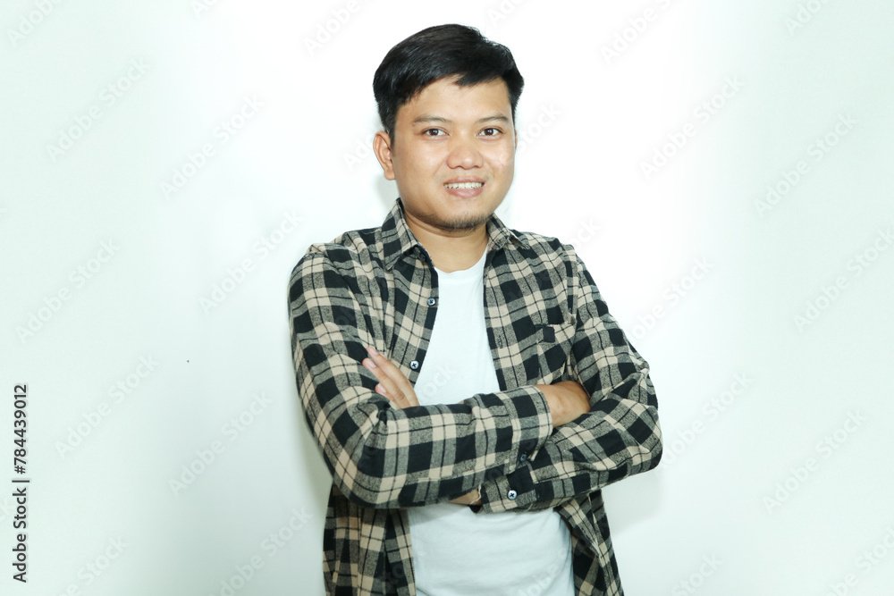 Young Asian man standing confident with arms crossed showing happy expression Young Asian man standing confident with arms crossed showing happy expression