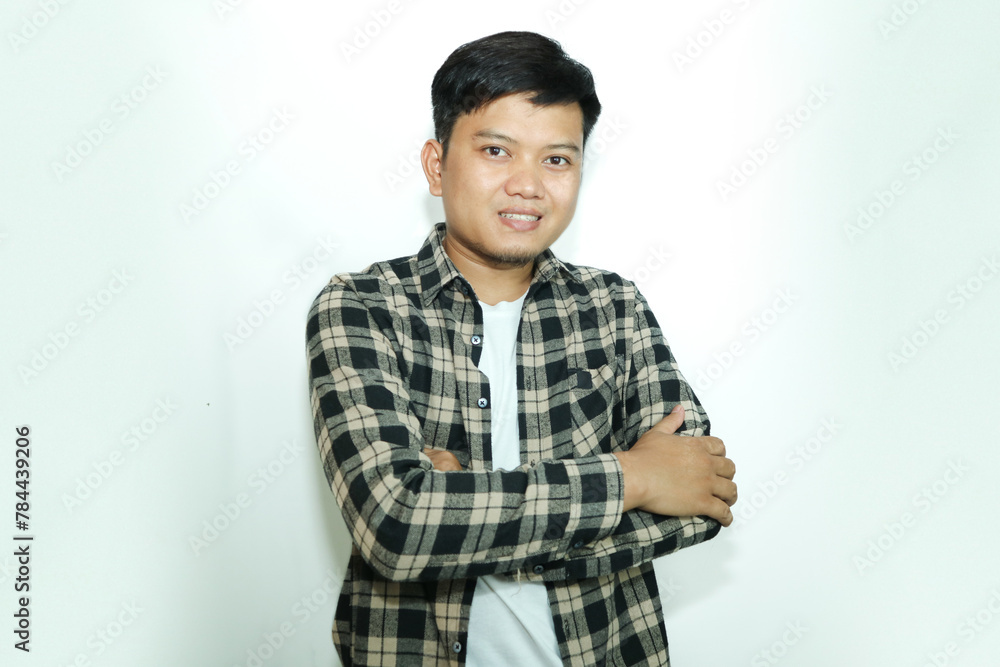 Young Asian man standing confident with arms crossed showing happy expression Young Asian man standing confident with arms crossed showing happy expression