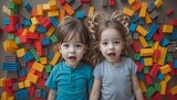 Young children enjoy playful moments with vibrant plastic blocks, while creative kindergarteners construct a tower. A top-down perspective captures the scene