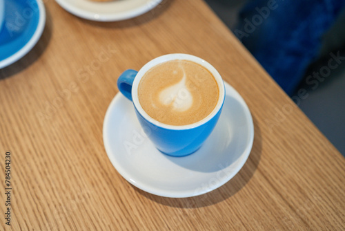 Overhead view of blue cup with coffee on the table